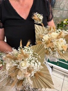 Bouquets de fleurs séchées avec roses blanches, gypsophile et feuilles de palmier pour un mariage bohème chic.