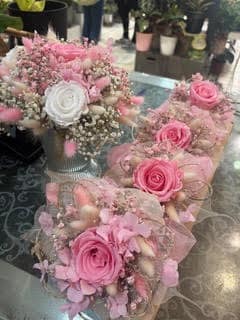 Bouquets de roses roses et blanches en fleurs séchées et stabilisées, idéals pour un mariage romantique.
